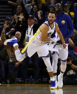 Golden State Warriors’ Stephen Curry (30) and Draymond Green celebrate a score against the Denver Nuggets duringa game Monday in Oakland, Calif. (AP Photo/Ben Margot)