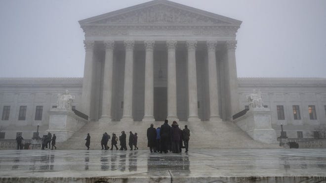 People line up in the fog at the U.S. Supreme Court in Washington to attend arguments, early Tuesday. (AP Photo/J. Scott Applewhite)