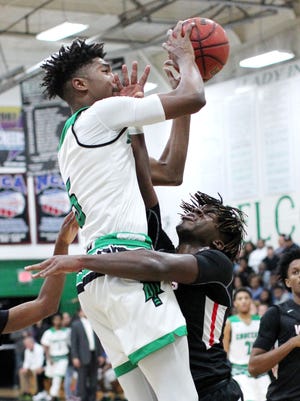 Choctaw's Diante Smith takes aim at the hoop despite being fouled by Fort Walton's Roderick Willis during their rivalry game at Choctaw.[MICHAEL SNYDER/DAILY NEWS]