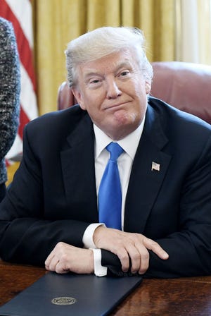 U.S. President Donald Trump looks on after signing an Executive Order Tuesday in the Oval Office of the White House in Washington, D.C. [Olivier Douliery/Abaca Press/TNS]