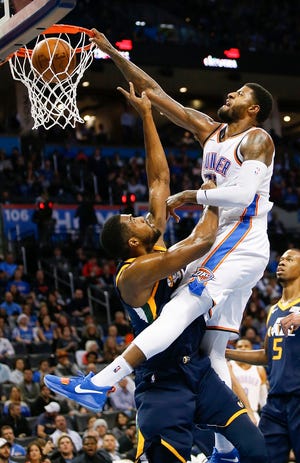 Oklahoma City's Paul George (13) dunks on Utah's Derrick Favors (15) during an NBA basketball game between the Oklahoma City Thunder and Utah Jazz at Chesapeake Energy Arena in Oklahoma City, Wednesday, Dec. 20, 2017. Oklahoma City won 107-79. Photo by Nate Billings, The Oklahoman Archives