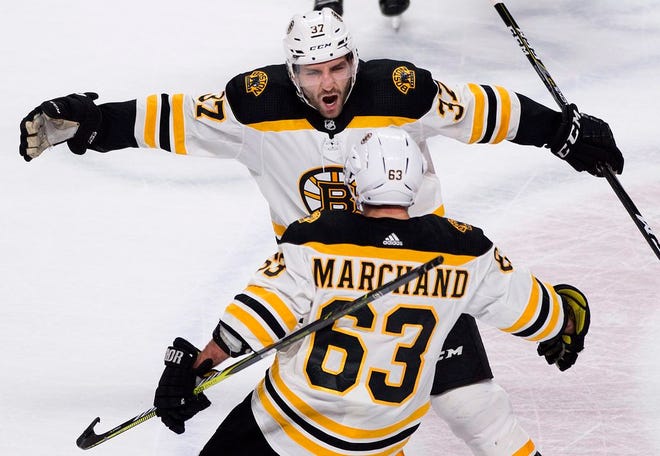 Boston Bruins' Brad Marchand (63) celebrates with teammate Patrice Bergeron after scoring against the Montreal Canadiens during the shootout in NHL hockey action in Montreal, Saturday, Jan. 13, 2018. (Graham Hughes/The Canadian Press via AP)