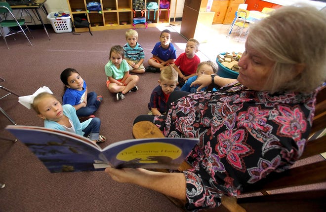 Sandra Harris reads her kindergartners 'The Kissing Hand' on their first day of school at Bethware Elementary. [Brittany Randolph/The Star]