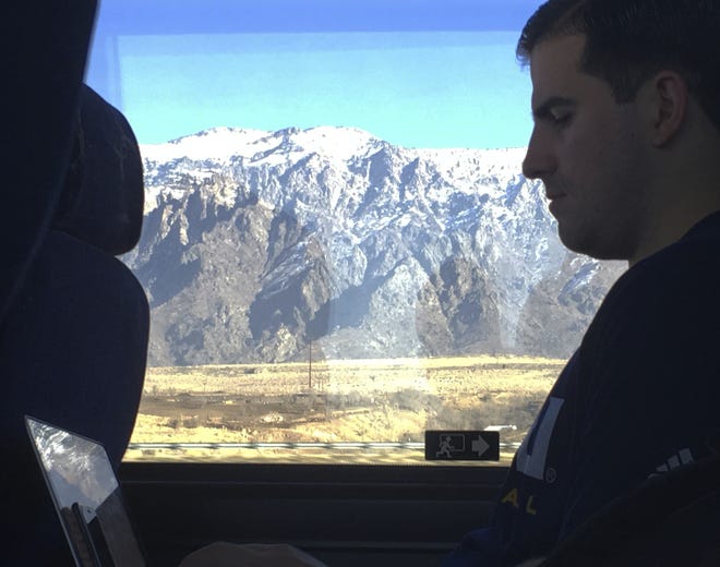 Northern Arizona assistant basketball coach Jason Sanchez goes over game film from the night before on a Jan. 5 bus ride to Pocatello, Idaho. The Lumberjacks lost to Weber State by 40, then had to leave the next day on a two-hour bus ride for a game against Idaho State before driving back through Ogden to Salt Lake City. [AP Photo / John Marshall]