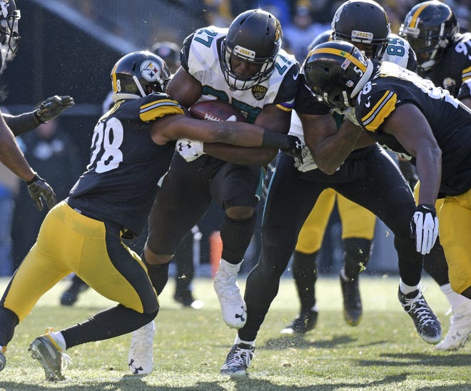 Jacksonville Jaguars running back Leonard Fournette (27) is tackled by Pittsburgh Steelers strong safety Sean Davis (28) during the first half of an NFL divisional football AFC playoff game in Pittsburgh, Sunday, Jan. 14, 2018. (AP Photo/Don Wright)