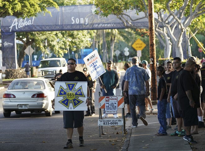 Members of the International Alliance of Theatrical Stage Employees strike outside the entrance to Sony Open golf tournament on Sunday. [AP Photo/Marco Garcia]