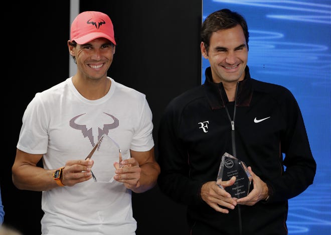Spain's Rafael Nadal, left, and Switzerland's Roger Federer hold their trophies for International tennis Writers Association "Ambassadors of the Year" awards on Saturday. [AP Photo/Vincent Thian]