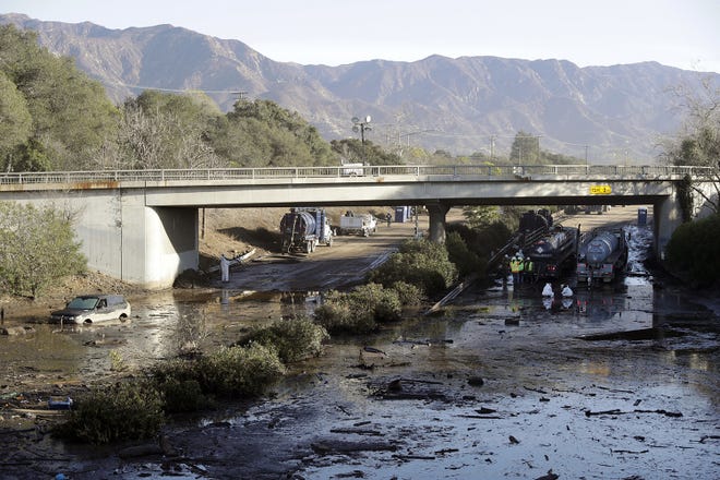 FILE - In this Jan. 13, 2018, file photo, crews work on clearing Highway 101 in the aftermath of a mudslide in Montecito, Calif. Officials say the possibility of future catastrophic floods will be in mind as Montecito rebuilds following deadly mudslides that devastated the wealthy coastal hideaway. (AP Photo/Marcio Jose Sanchez, File)