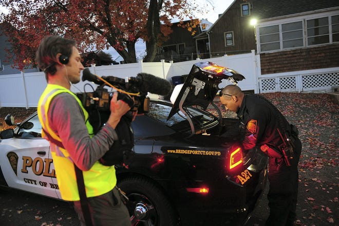 In this Nov. 3, 2016, photo, a crew from the television program "Live PD," a reality show by the A&E Network, records an officer from the Bridgeport Police Department while on patrol in Bridgeport, Conn. Some law enforcement agencies, including the Bridgeport Police, have ended their agreements to be on the show after local government leaders concluded the national spotlight on criminal activity overshadowed the positive things happening in their hometowns. [Christian Abraham/Hearst Connecticut Media via AP]
