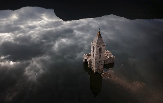 A church and remains of an ancient village, which are usually covered by water are seen inside the reservoir of Sau, in Vilanova de Sau, Catalonia, Spain, Thursday. One reservoir built in the early 1960s, submerging a village called San Roman de Sau and its 11th century romanesque church, is so low on water that the ruins of buildings that are usually under water are now uncovered. (AP Photo/Emilio Morenatti)