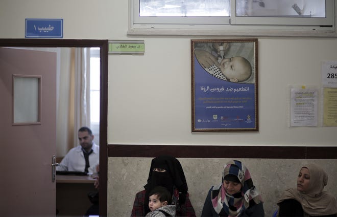 In this Sunday Jan. 14, 2018 photo, Palestinian women wait to see a doctor in the UNRWA-run clinic in the Shati refugee camp, Gaza City. From the Gaza Strip to Jordan and Lebanon, millions of Palestinians are bracing for the worst as the Trump administration moves toward cutting funding to the U.N. agency that assists Palestinian refugees across the region. The expected cuts could deliver a painful blow to some of the weakest populations in the Middle East and risk destabilizing the already struggling countries that host displaced Palestinian refugees and their descendants. (AP Photo/ Khalil Hamra)