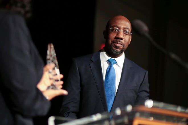 FILE - In this Jan. 13, 2017, file photo, Pastor Raphael Gamaliel Warnock, of Ebenezer Baptist Church, receives a “President’s Fulfilling the Dream Award” during during a Martin Luther King Celebration at the Tate Student Center at the University of Georgia in Athens, Ga. In response to Martin Luther King’s teachings about love and hate, Warnock says that now “is a time of moral reckoning in our nation. We must choose to stand on the side of light and love.” (John Roark/Athens Banner-Herald via AP, File)
