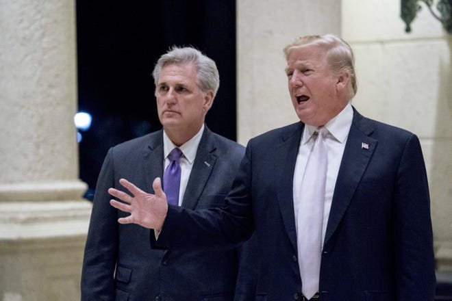 President Donald Trump, right, accompanied by House Majority Leader Kevin McCarthy, R-Calif., speaks to members of the media as they arrive for a dinner at Trump International Golf Club in West Palm Beach, Fla., Sunday, Jan. 14, 2018. (AP Photo/Andrew Harnik)