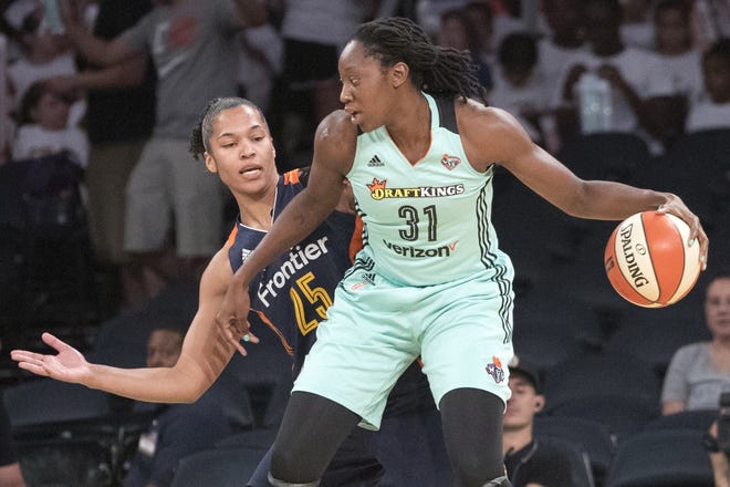 New York Liberty center Tina Charles (31) drives to the basket against Connecticut Sun forward Alyssa Thomas (25) in July. The Liberty locked in Charles on Monday, designating her a franchise player. [The Associated Press]