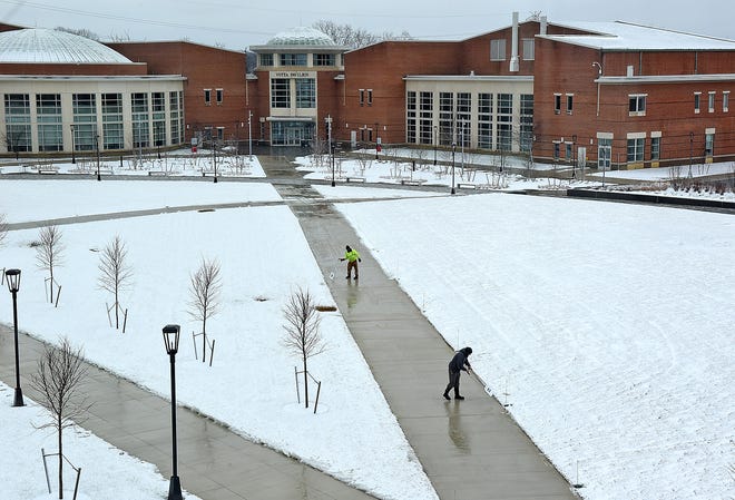 Grounds crew employees clear the walkways at Rowan College at Burlington County in Mount Laurel after another snowstorm on Wednesday, Jan. 17, 2018. [NANCY ROKOS / STAFF PHOTOJOURNALIST]