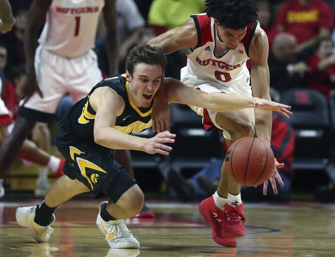 Iowa' Nicholas Baer (left) and Rutgers' Geo Baker (0) battle for a loose ball during Wednesday's game in Piscataway, N.J. [JOHN MUNSON/NJ ADVANCE MEDIA]