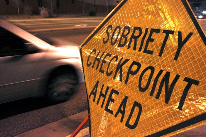 FILE - In this Dec. 29, 2011 file photo, a car approaches a sobriety checkpoint set up along a busy street in Albuquerque, N.M. A prestigious scientific panel is recommending that states significantly lower their drunken driving thresholds as part of a blueprint to eliminate the “entirely preventable” 10,000 alcohol-impaired driving deaths in the United States each year. (AP Photo/Susan Montoya Bryan)
