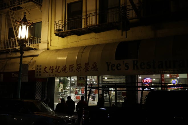 In this photo taken Thursday, Dec. 21, 2017, a group of people wait outside a restaurant at night on Chinatown’s Grant Avenue in San Francisco. The avenue, which runs north and south, is one of the oldest streets in the city. In the late 1800s the street became home to Chinese immigrants who were escaping persecution or following the Gold Rush. Many of the current buildings in the neighborhood can be traced to the reconstruction efforts after the 1906 earthquake. (AP Photo/Eric Risberg)