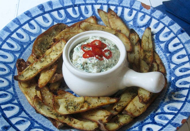 This Jan. 9 2018 photo shows potato skins baked with roasted garlic rosemary butter and an onion kale dip spiked with fresh chiles. This dish is from the recipe “Decadent Snacks for the Super Bowl” by Sara Moulton. (Sara Moulton via AP)