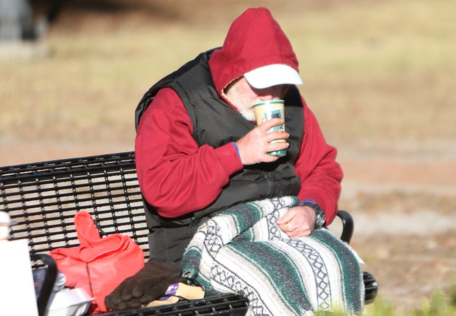 A homeless man sips hot coffee and warms up under a blanket. The Panama City Rescue Mission passed out hot coffee, blankets, coats and other items to help the local homeless get through the next few cold nights. Go to newsherald.com for a related video.[PATTI BLAKE/THE NEWS HERALD]