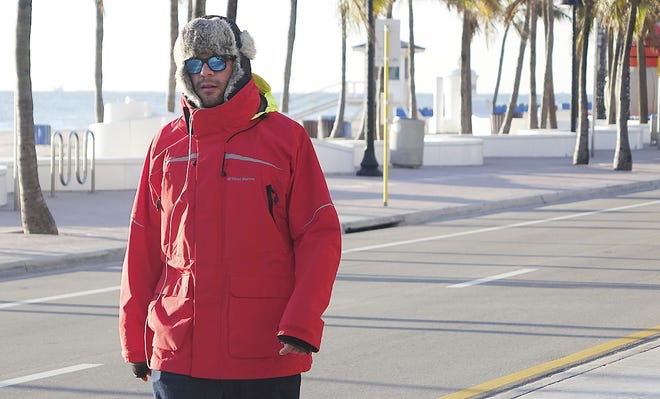 Dominic Tamerlano, of Fort Lauderdale, Fla., walks down a street Thursday. Colder than normal temperatures greeted South Floridians Thursday morning. [JOE CAVARETTA/SOUTH FLORIDA SUN-SENTINEL/ASSOCIATED PRESS]