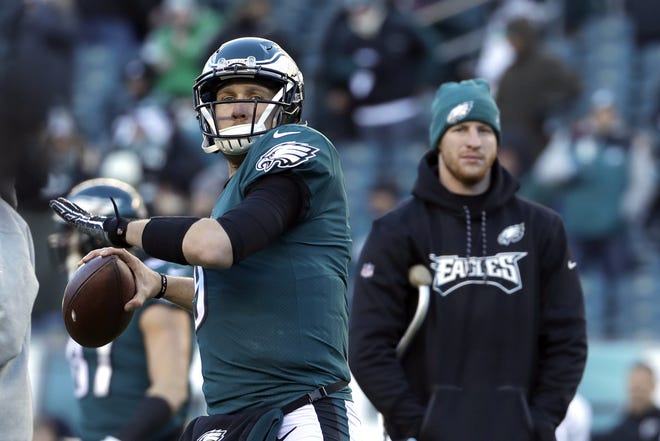 Philadelphia Eagles quarterback Nick Foles, left, warms up as Carson Wentz looks on before a divisional playoff game against the Atlanta Falcons in Philadelphia, Saturday. [The Associated Press / Michael Perez]