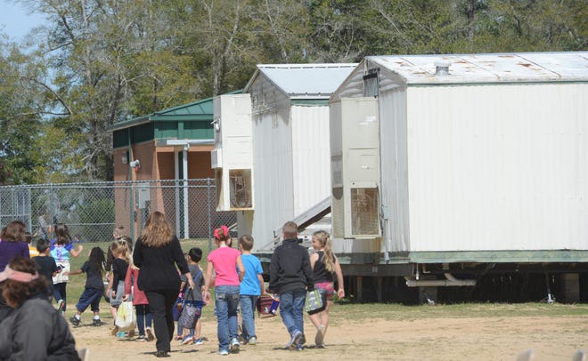 Bob Sikes Elementary School students walk by portable classrooms at the school in Crestview. [DEVON RAVINE/DAILY NEWS]