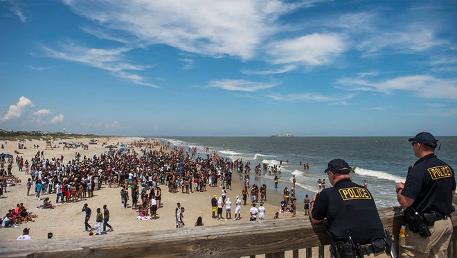 Police officers watch the crowds during the 2017 Orange Crush event. While city officials approved restrictions on open air alcohol consumption last year, there was not enough support to pass a similar measure during the Tybee City Council's meeting last week. (Savannah Morning News file photo)