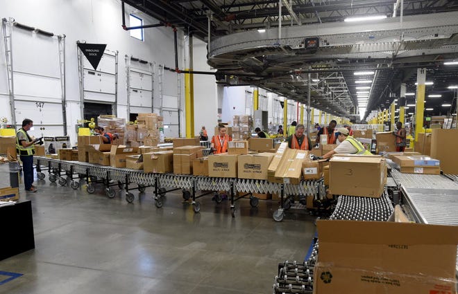 FILE PHOTO: This Oct. 27, 2015, photo shows employees in the receiving area at the Amazon Fulfillment Center in Lakeland.