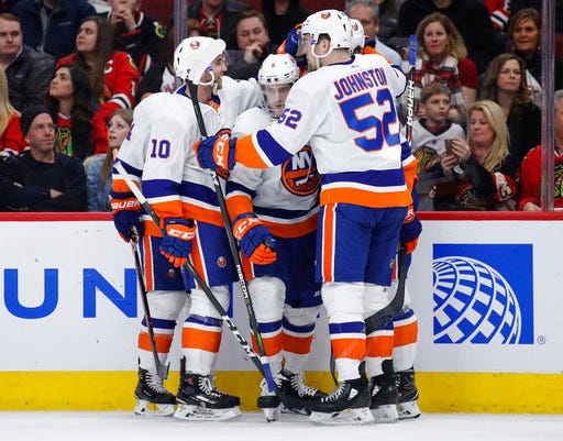 New York Islanders defenseman Ryan Pulock (6) celebrates with teammates after scoring against the Chicago Blackhawks during the first period of an NHL hockey game Saturday, Jan. 20, 2018, in Chicago. (AP Photo/Kamil Krzaczynski)