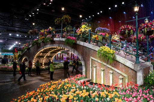 FILE - In this March 10, 2017, file photo, visitors view horticultural displays during a preview of the annual Philadelphia Flower Show, featuring the theme "Holland: Flowering the World," at the Pennsylvania Convention Center in Philadelphia. As the East Coast slogs through chilly temperatures and winter dreariness, visitors will dive into spring during the annual Philadelphia Flower Show from March 3 to 11, 2018, featuring the theme "Wonders of Water" and promising to "celebrate the beauty and life-sustaining interplay of horticulture and water." (AP Photo/Matt Rourke, File)