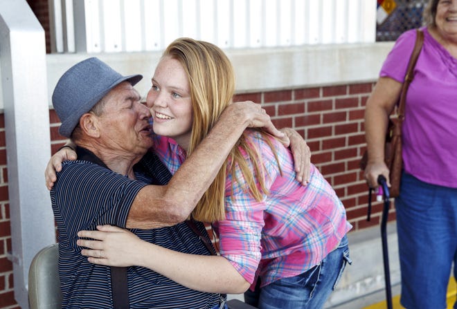 Ashley Aldridge greets Earl Moorman, whom she freed from his electric wheelchair after it got stuck on a railroad crossing in 2015. [File/The State Journal-Register]