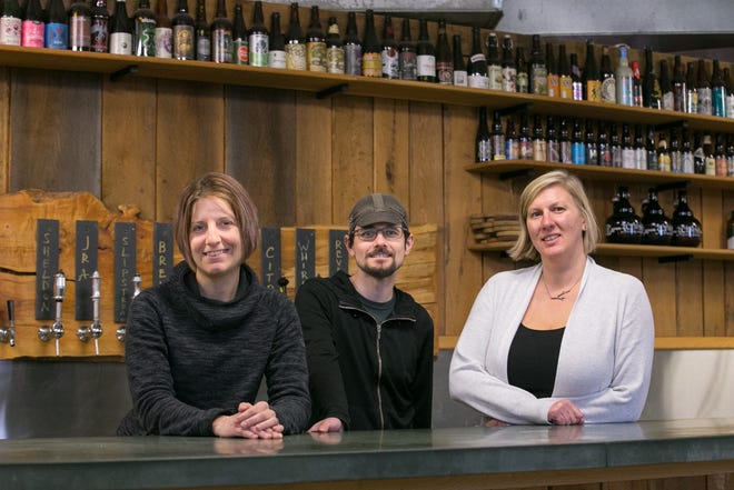 From left, 3Cross Brewing Co. community coordinator Jessica Howland, president and brewer David Howland and taproom manager Heather Odell in the 3Cross taproom in Worcester.  [Photo/Matthew Healey]