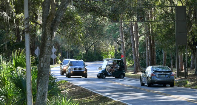 Traffic stops so golfers can cross Longmeadow in The Meadows in Sarasota. [Herald-Tribune staff photo / Mike Lang]