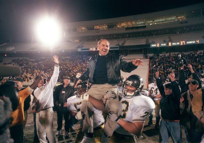 Clinton High School football coach Bob Lewis, being carried by Jay Little, No. 73, right, and Larry Sampson, No. 52, left, celebrates Clinton's Dec. 13, 1997 state 2A championship win over Shelby at Kenan Stadium in Chapel Hill. At left is player Micah Brewington, No. 12. [Steve Aldridge/The Fayetteville Observer]