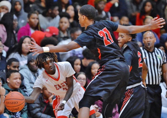 East's Tyler Price (left) gets a pass off against Buchtel's Jonathan King (21) and Ja'Shawn Campbell (2) during the second quarter of their basketball game at East High School, Tuesday in Akron. (Jeff Lange/ABJ/Ohio.com correspondent)