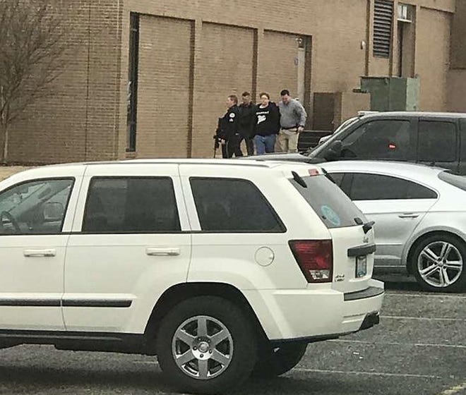 Police escort a person, second from right, out of the Marshall County High School after shooting there, Tuesday, Jan 23, 2018, in Benton, Ky. Gov. Matt Bevin said two people were killed and 19 injured in the shooting. (Dominico Caporali via AP)