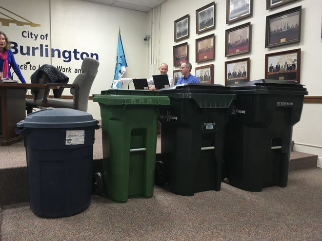 From left, 32-gallon can, a 35-gallon can, a 65-gallon can and a 95-gallon trash cans are seen in the Burlington City Council chamber Monday. Burlington currently uses the 32-gallon size, but there is a proposal to switch to the 65-gallon can. [Tanner Cole/thehawkeye.com]