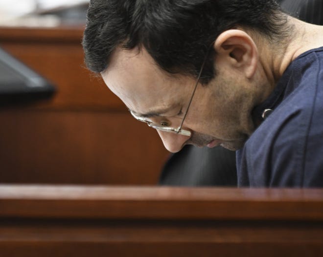 Larry Nassar hangs his head as former gymnast Amanda Thomashow gives her victim statement Tuesday, Jan. 23, 2018, in Ingham County Circuit Court in Lansing, Mich. Nassar, 54, has admitted sexually assaulting athletes under the guise of medical treatment when he was employed by Michigan State University and USA Gymnastics, which as the sport's national governing organization trains Olympians. He already has been sentenced to 60 years in prison for child pornography. Under a plea bargain, he faces a minimum of 25 to 40 years behind bars in the molestation case. (Matthew Dae Smith/Lansing State Journal via AP)