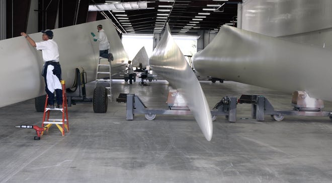 Workers put the finishing touches on wind turbine blades in September 2007 at the Siemens plant outside Fort Madison. The company began a round of layoffs Tuesday, starting with an announcement to third-shift workers. Additional employee meetings are planned for Wednesday. [John Gaines/thehawkeye.com]