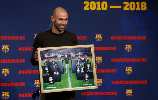 FC Barcelona's Javier Mascherano poses with a picture with FC Barcelona trophies during his farewell event at the Camp Nou stadium in Barcelona, Spain, Wednesday, Jan. 24, 2018. Barcelona have confirmed Javier Mascherano has signed with Chinese Super League outfit Hebei China Fortune after eight year in Barcelona. (AP Photo/Manu Fernandez)
