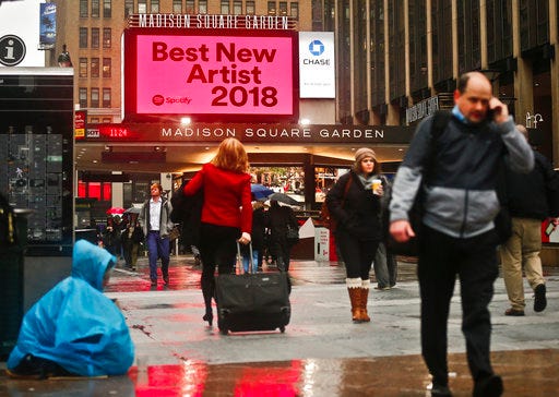 People walk near Madison Square Garden, Tuesday Jan. 23, 2018, in New York, the location for the 60th annual Grammy Awards which will be held on Sunday. (AP Photo/Bebeto Matthews)