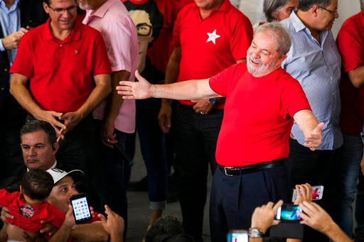 Former President Luiz Inacio Lula da Silva greets supporters during a visit to the metallurgic syndicate headquarters in Sao Bernardo do Campo, Brazil, Wednesday, Jan. 24, 2018. An appellate court in Brazil is considering whether to uphold or throw out a corruption conviction against da Silva, a decision that could impact whether the former leader can run for president. The 72-year-old leads preference polls for October’s race. (AP Photo/Marcelo Chello)
