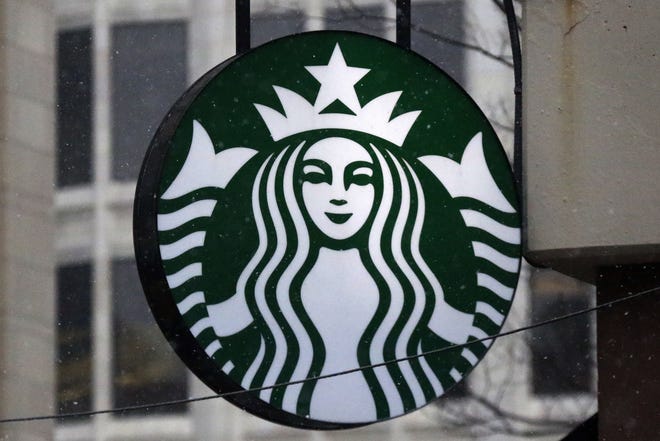 This file photo shows the Starbucks logo on a shop in downtown Pittsburgh. Starbucks is giving its U.S. workers pay raises and stock bonuses in 2018, citing recent tax reform. [AP Photo/Gene J. Puskar, File]