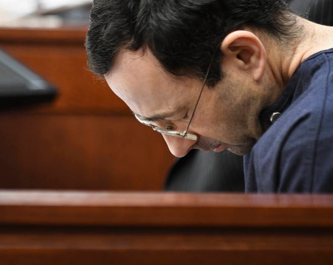 Larry Nassar hangs his head as former gymnast Amanda Thomashow gives her victim statement Tuesday, Jan. 23, 2018, in Ingham County Circuit Court in Lansing, Mich. Nassar, 54, has admitted sexually assaulting athletes under the guise of medical treatment when he was employed by Michigan State University and USA Gymnastics, which as the sport’s national governing organization trains Olympians. He already has been sentenced to 60 years in prison for child pornography. Under a plea bargain, he faces a minimum of 25 to 40 years behind bars in the molestation case. (Matthew Dae Smith/Lansing State Journal via AP)