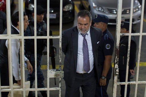 Ingmar Walterio Iten Rodriguez, a Guatemalan businessman, is transferred in handcuffs through the basement of a courthouse after his arrest in Guatemala City, Thursday, Jan. 25, 2018. Iten Walterio is one of several Guatemalan businessmen and former government officials arrested on charges of corruption and tax evasion. (AP Photo/Luis Soto)