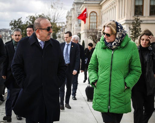 Turkey's Foreign Minister Mevlut Cavusoglu, right, and Austria's Foreign Minister Karin Kneissl speak as they walk along the Bosporus before official talks and a joint press conference in Istanbul, Thursday, Jan. 25, 2018.(Cem Ozdel/Pool Photo via AP)