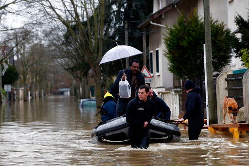 Rescue workers evacuate residents in a flooded street of Villeneuve-Saint-Georges, outside Paris, where the Yerres river floods Thursday, Jan.25, 2018. Rivers across France kept swelling as more rain hit the country Thursday, with 15 departments across the country remaining on alert for floods. In addition to Paris, where the Seine river is expected to keep rising until Saturday, the other regions threatened are in the north and east of the country. (AP Photo/Christophe Ena)