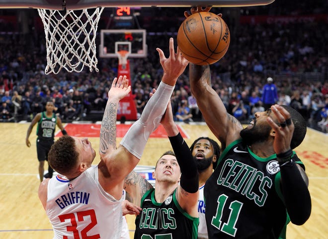 Los Angeles Clippers forward Blake Griffin, left, and Boston Celtics guard Kyrie Irving, right, compete for a rebound along with Celtics forward Daniel Theis, second from left, of Germany, and Clippers center DeAndre Jordan during the second half of an NBA basketball game Wednesday, Jan. 24, 2018, in Los Angeles. The Celtics won 113-102.