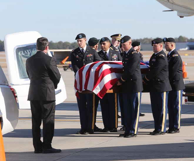 A Fort Rucker honor guard transfers the remains of World War II airman Ewart Sconiers from a jet to a hearse on the tarmac at Pensacola International Airport. Military officials, family and friends worked for years to positively identify Sconiers' remains and bring them home for burial. [MICHAEL SNYDER/GATEHOUSE MEDIA]